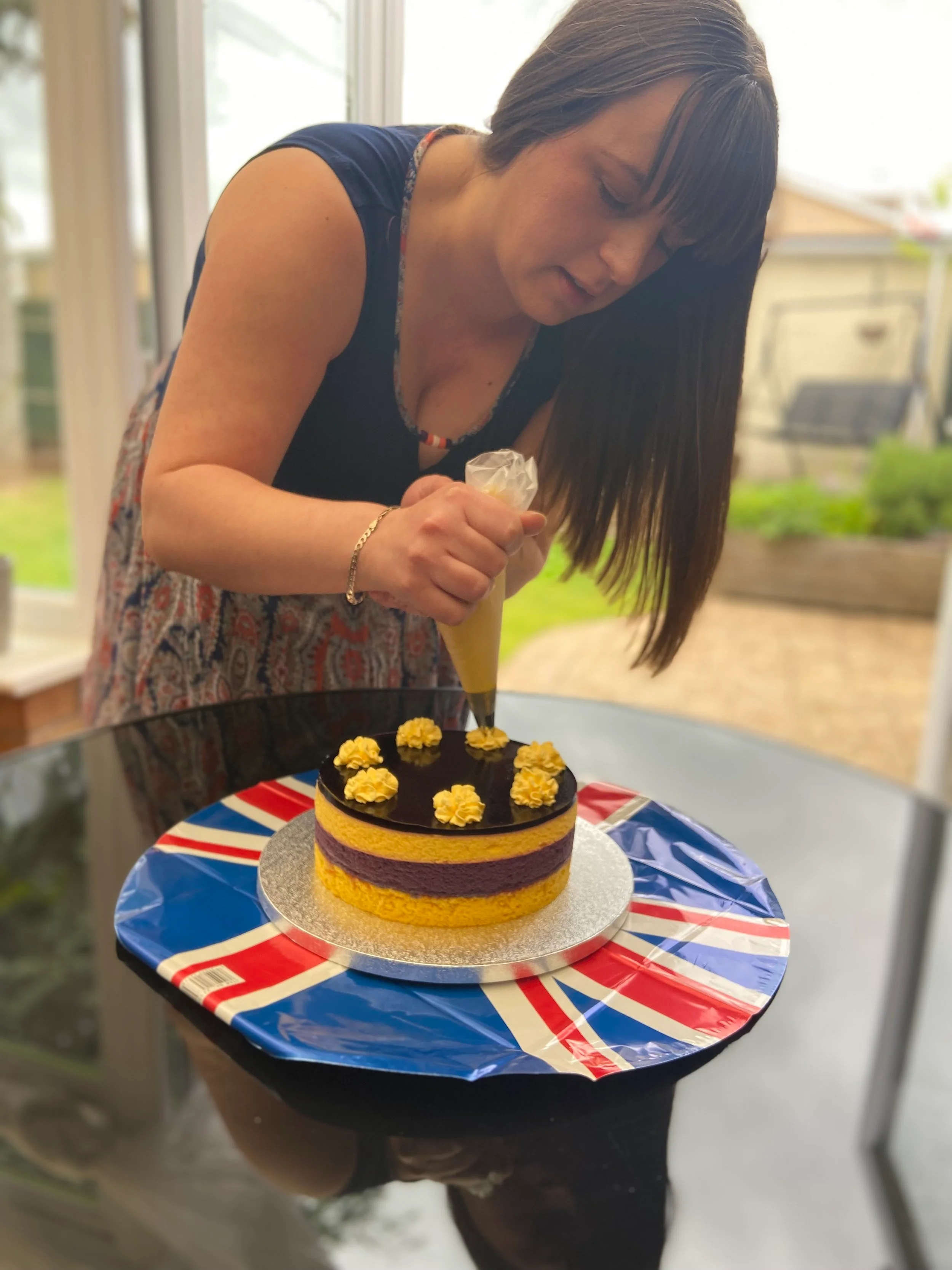 Danielle Malik decorating her cake with whipped cream swirls