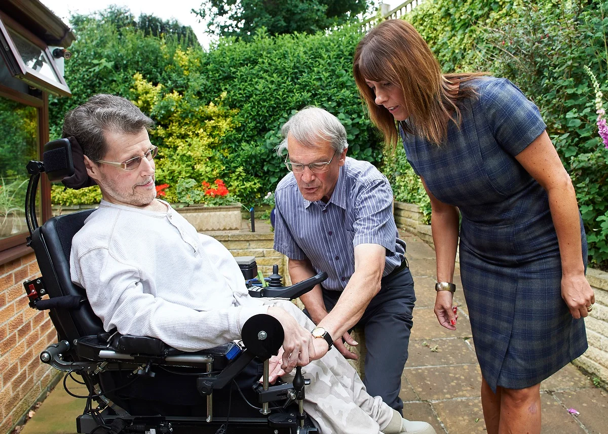 From left, Richard Shaw, who has a muscle-wasting disease and has benefitted from the work of Remap, discusses a modification to his chair with Remap volunteer Mike Banks and Jane Spencer, secretary of Hazelwood chemical company Lubrizol’s Charities…