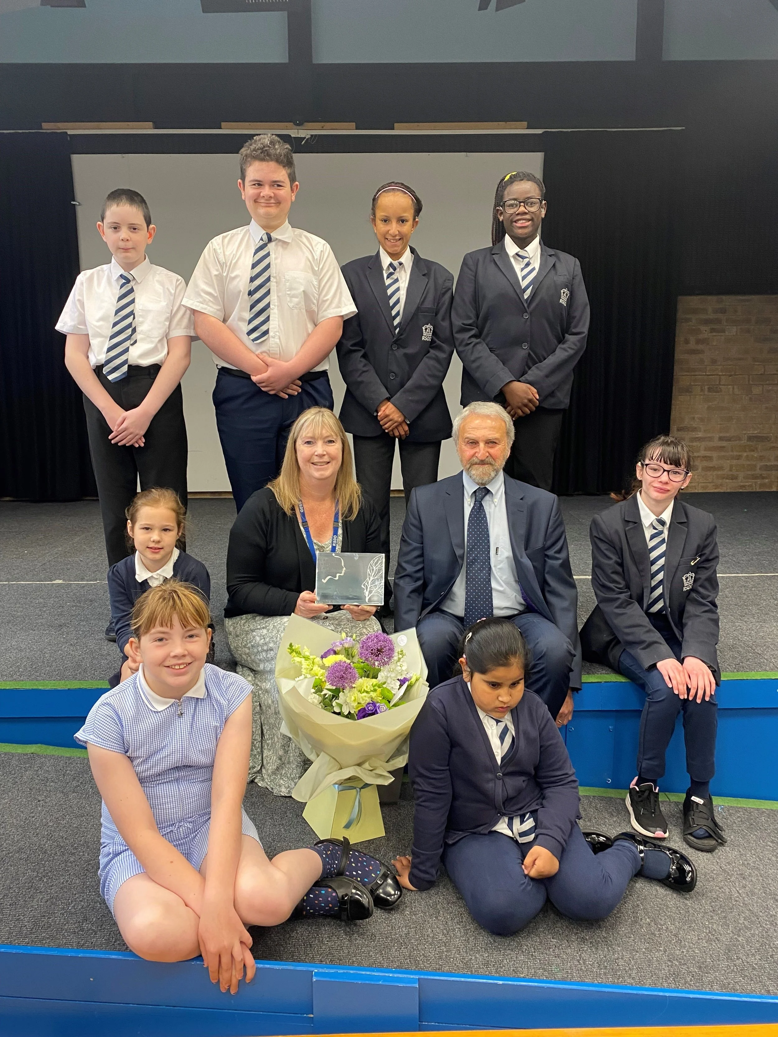 Headteacher of Royal School for the Deaf Derby Helen Shepherd holding her Silver Award, with pupils from the school and Tim Sylvester, the man who appointed her and presented her with the award.