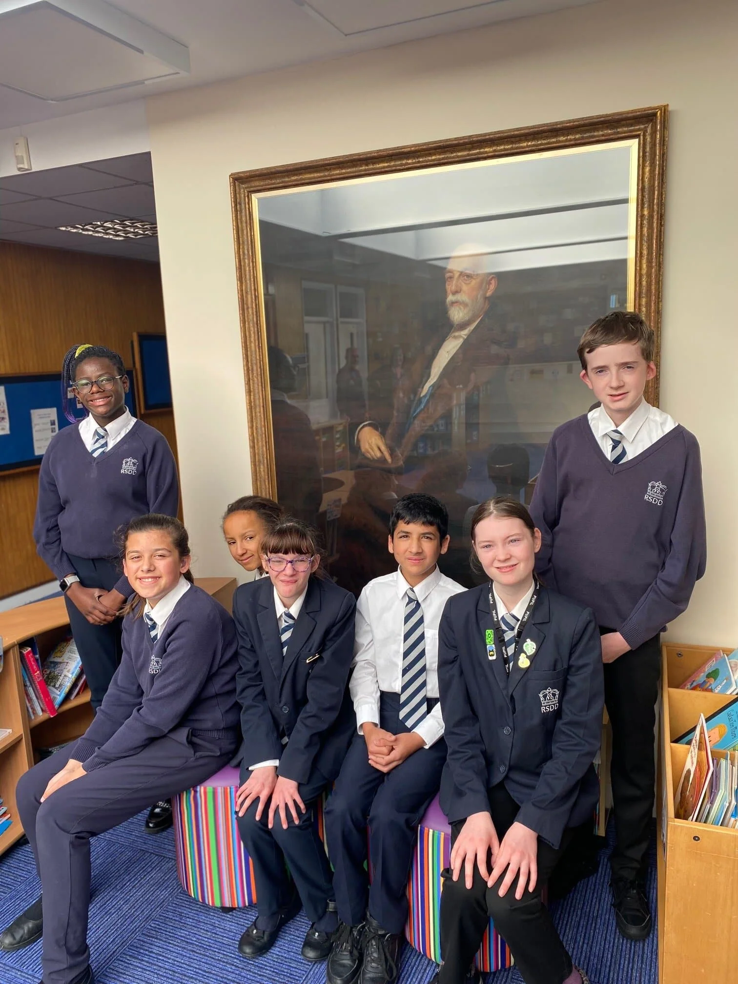 Pupils of The Royal School for the Deaf in Derby stood with portrait.