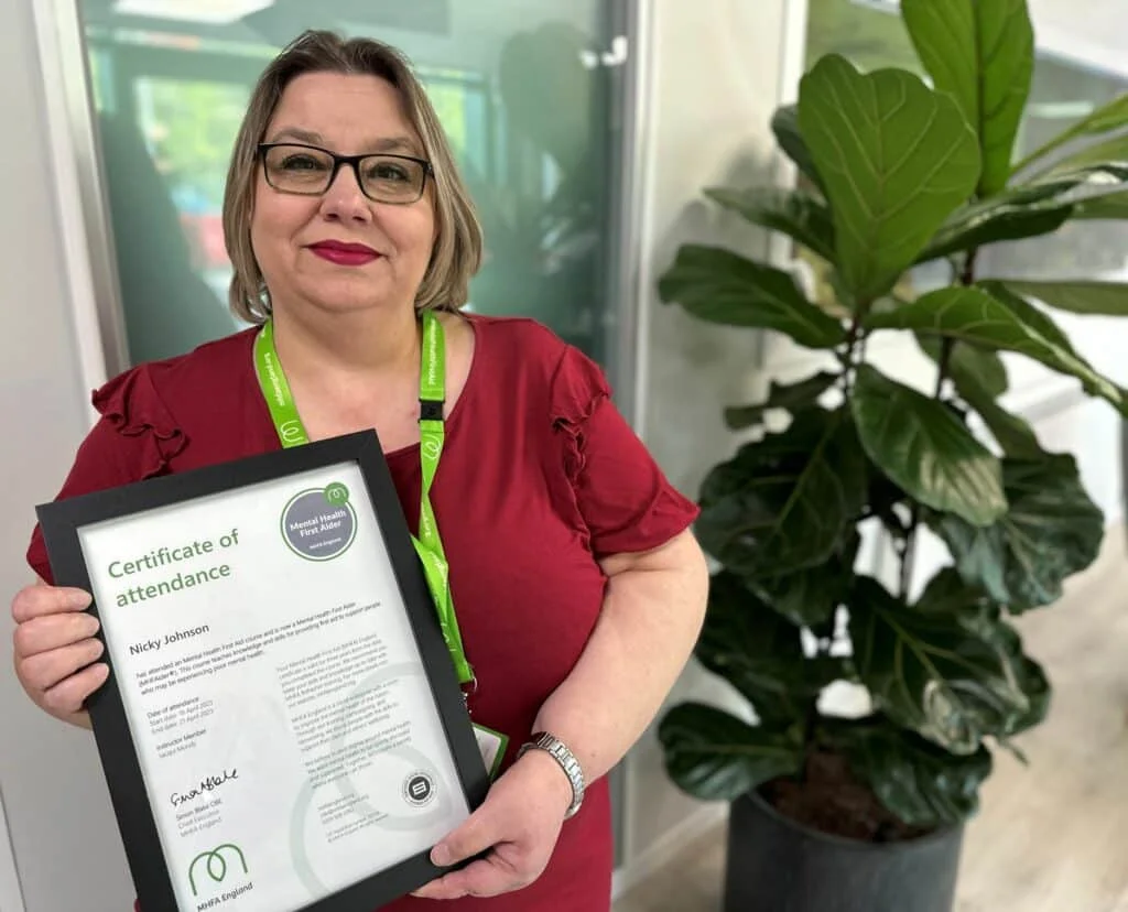 Nicky Johnson holding her "Mental Health First Aider" certificate