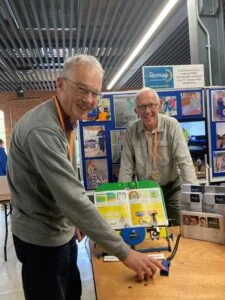 Mike Banks, (left) with Peter Brien, chair of the Derby, Burton & District Remap, and the book turning device for disabled children