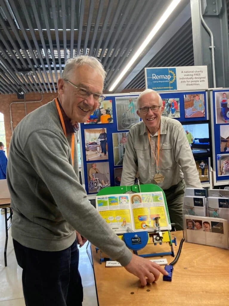 Mike Banks with Peter Brien, chair of the Derby, Burton & District Remap, and the book turning device for disabled children