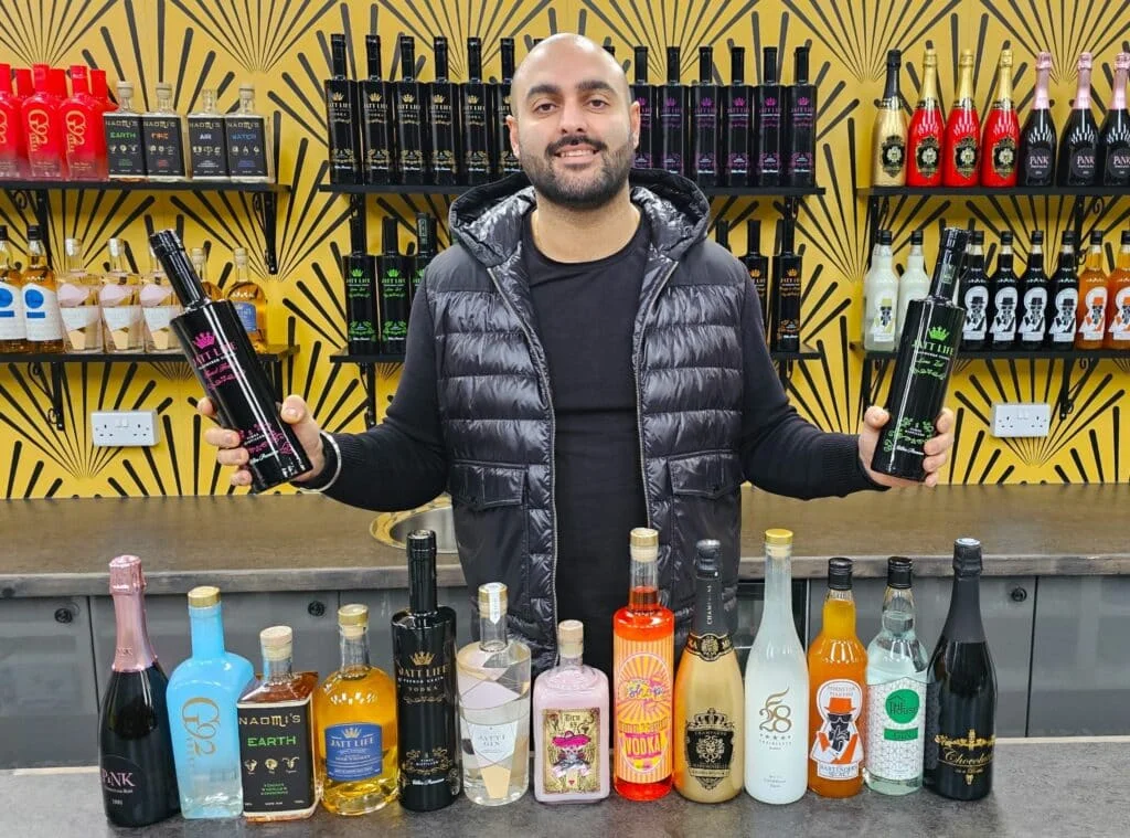 Baz Kooner of Virtus Brands displays a range of bottles of spirits and wines available in his range.