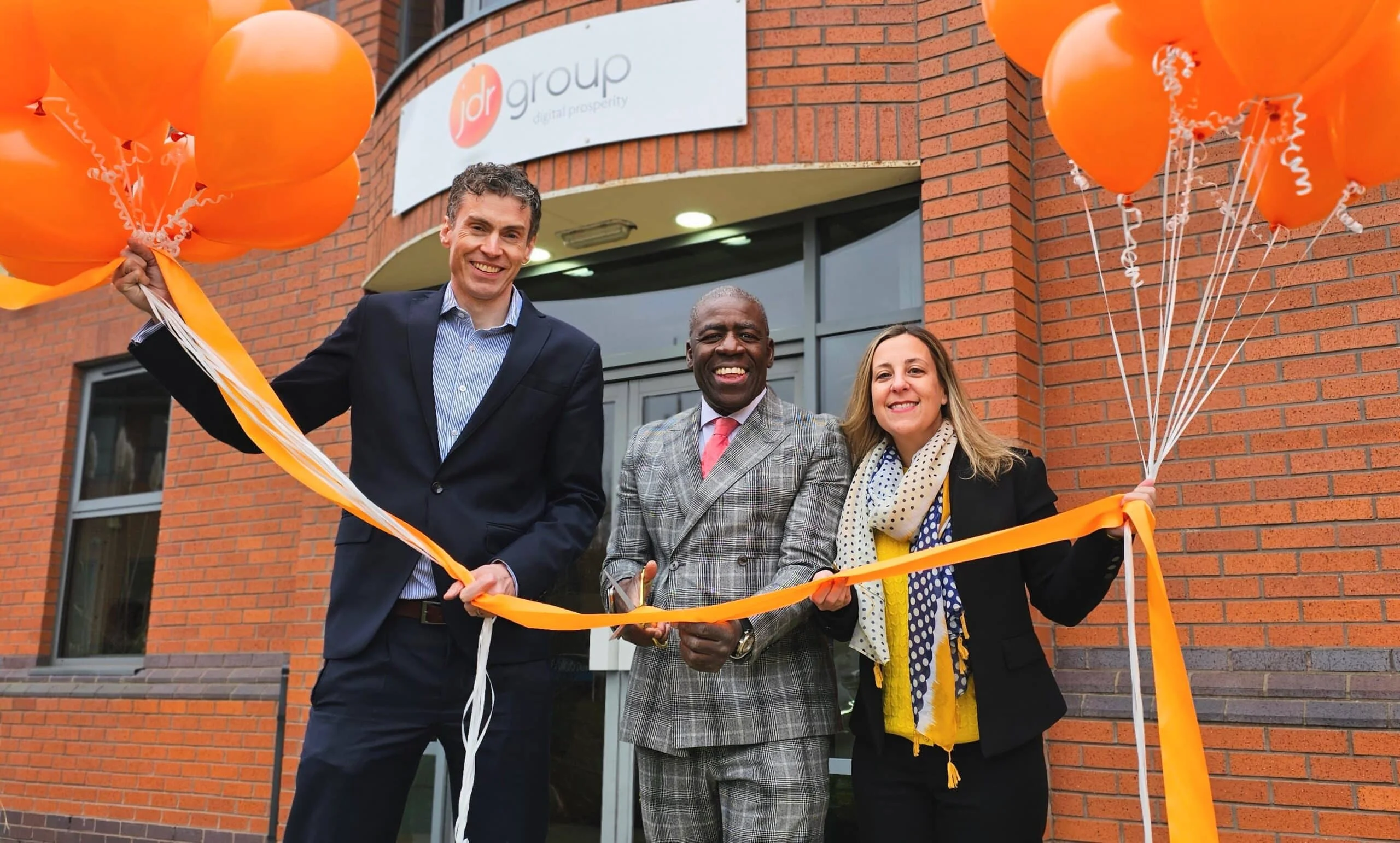 From left, director Will Williamson, owner and founder David Roberts and finance and operations director Leanne Mordue cut the ribbon on Derby digital marketing firm JDR Group’s new premises in Wyvern Business Park