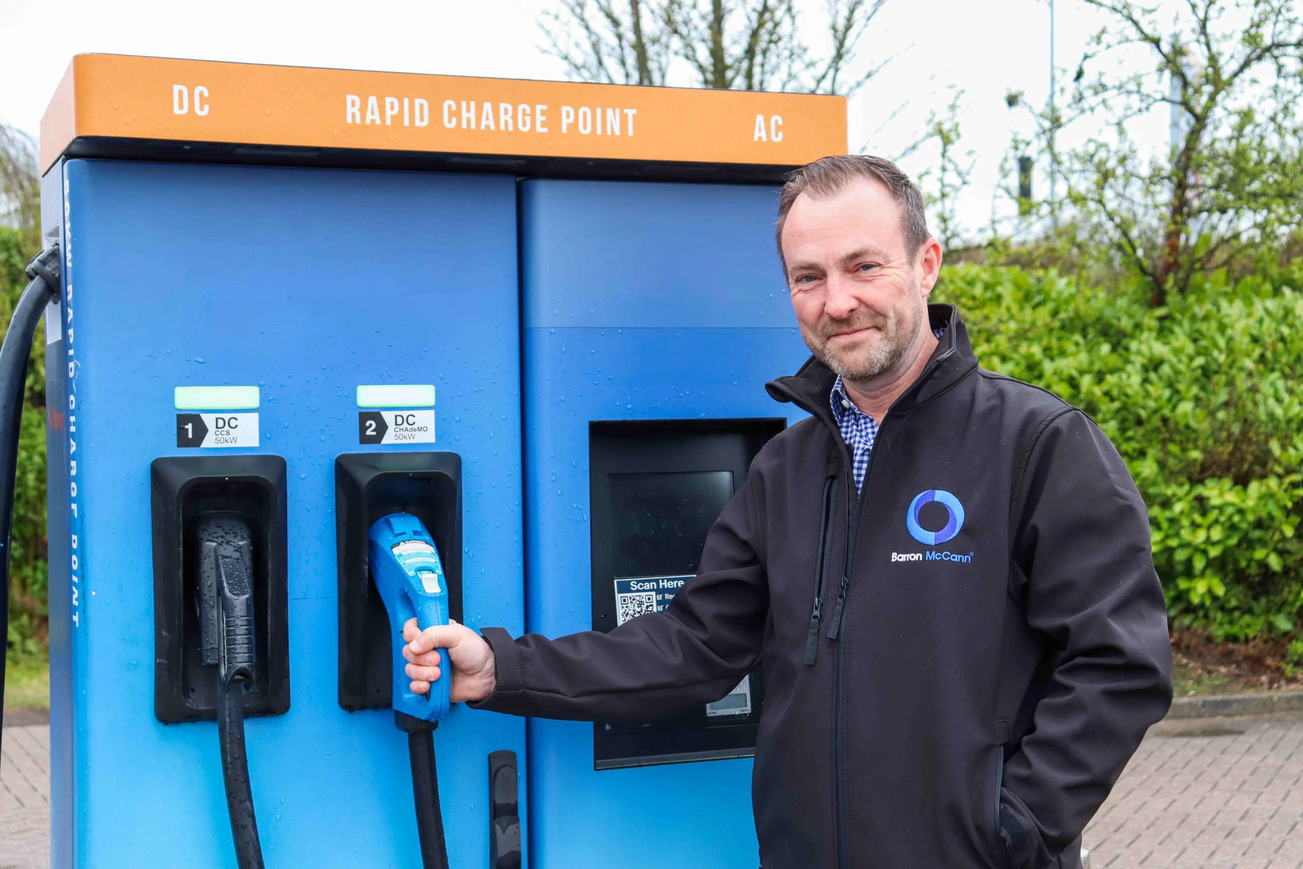 Steve Smiling from Barron McCann with an EV charging point