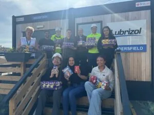 Photo shows 10 Huddersfield Lubrizol employees each holding Easter eggs which were donated to Forget-me-Not Hospice