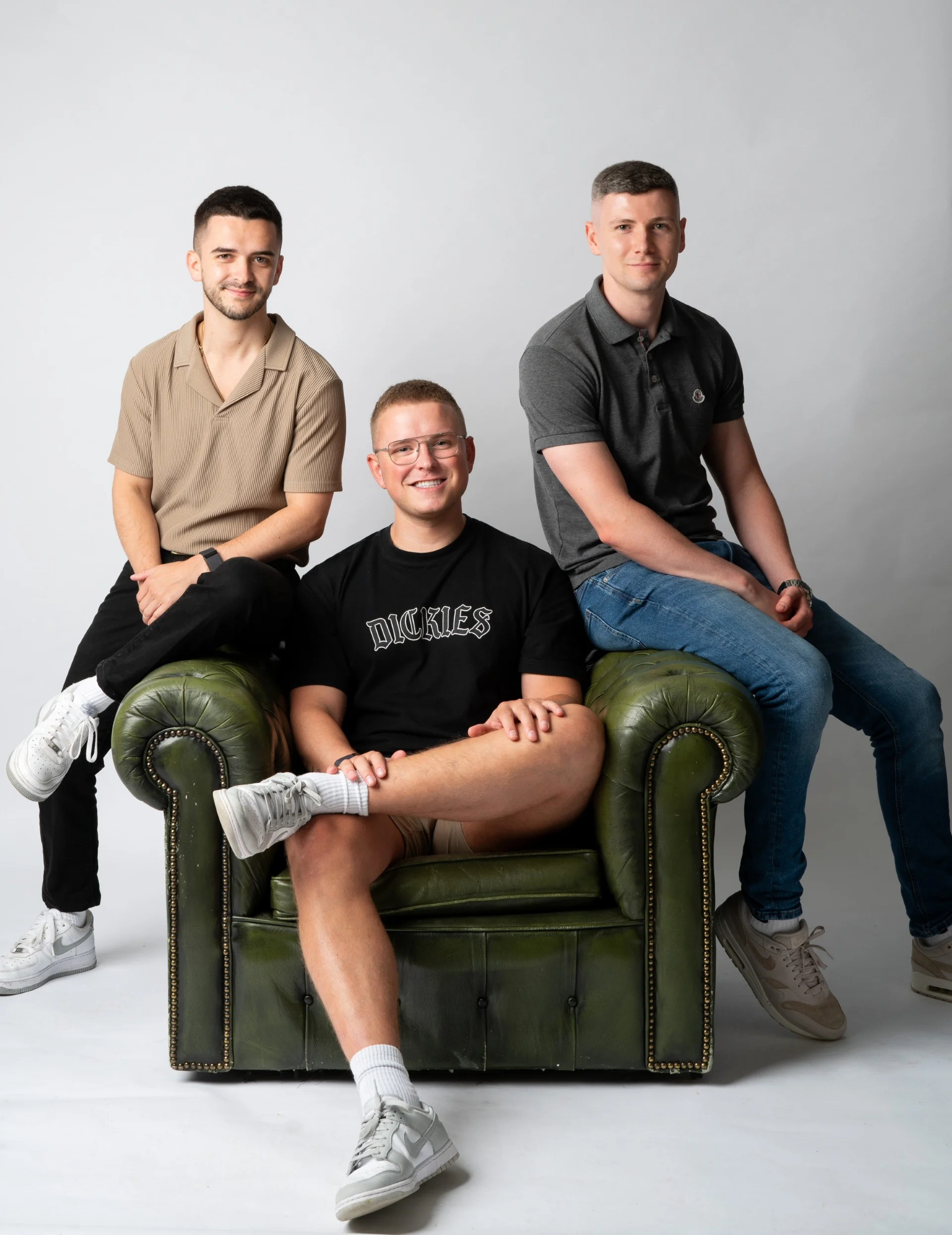 three memebers of the alphageek team sat on a green chair